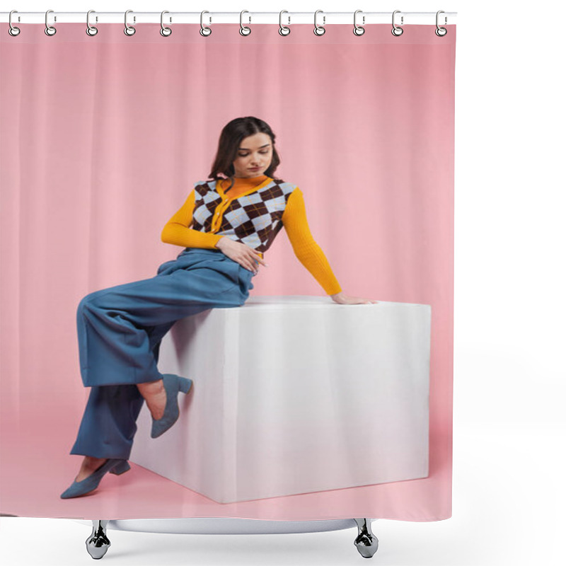 Personality  Full Length Of Brunette Woman In Blue Pants And Trendy Cardigan Sitting On White Cube On Pink Background Shower Curtains