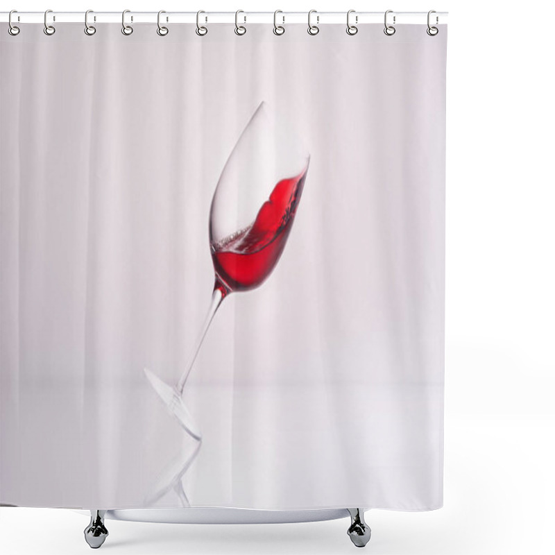 Personality  Close-up Shot Of Inclined Wineglass With Splashing Red Wine On Reflective Surface And On White Shower Curtains