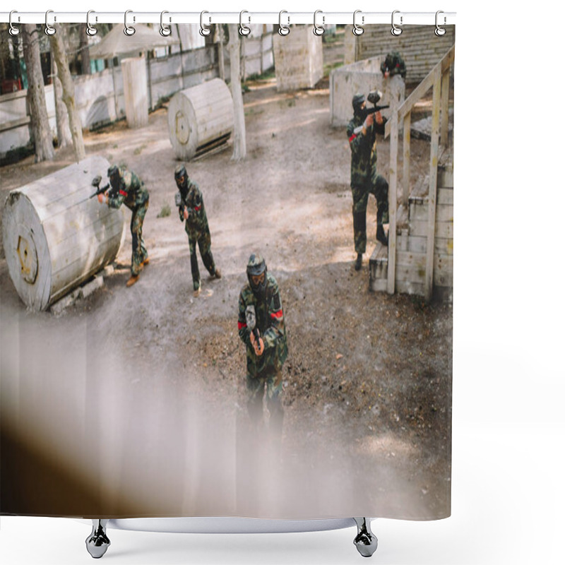 Personality  High Angle View Of Paintball Team In Uniform And Protective Masks Playing Paintball With Markers Guns Outdoors Shower Curtains