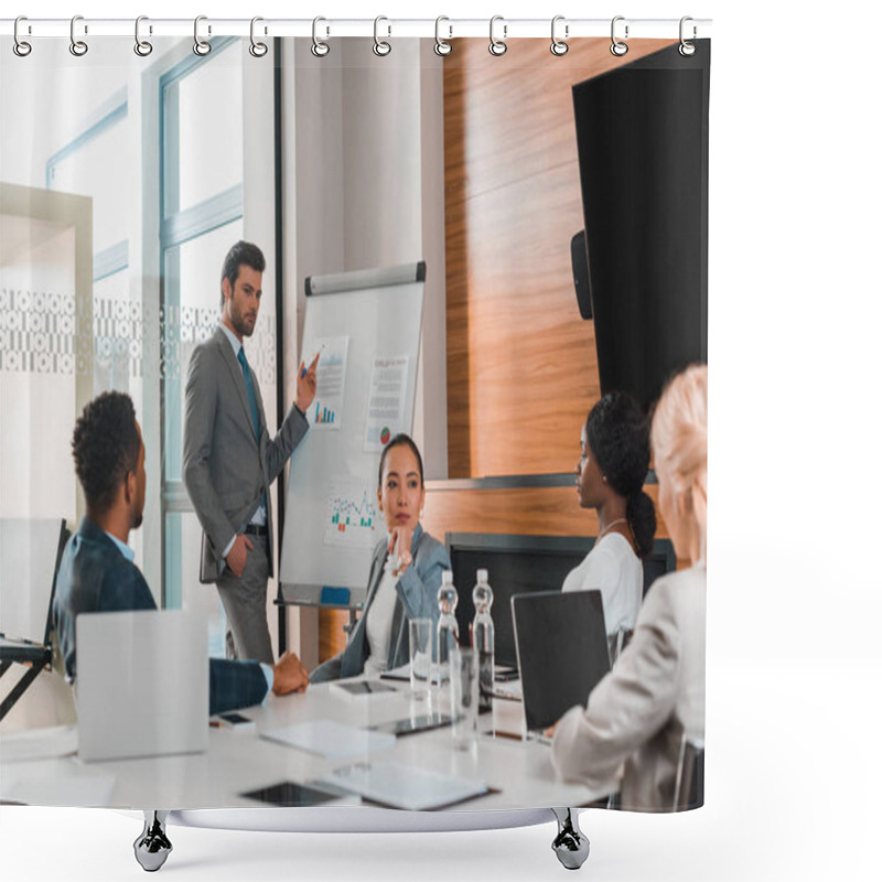 Personality  Handsome Businessman Pointing With Finger At Flipchart With Infographics While Multicultural Colleagues Sitting At Desk In Conference Hall Shower Curtains