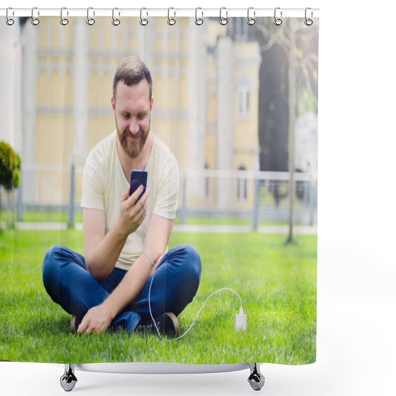 Personality  Nature And Technology. A Man With A Beard Lies On A Green Grass With A Smartphone In His Hands Is Charging Power Bank. Shower Curtains