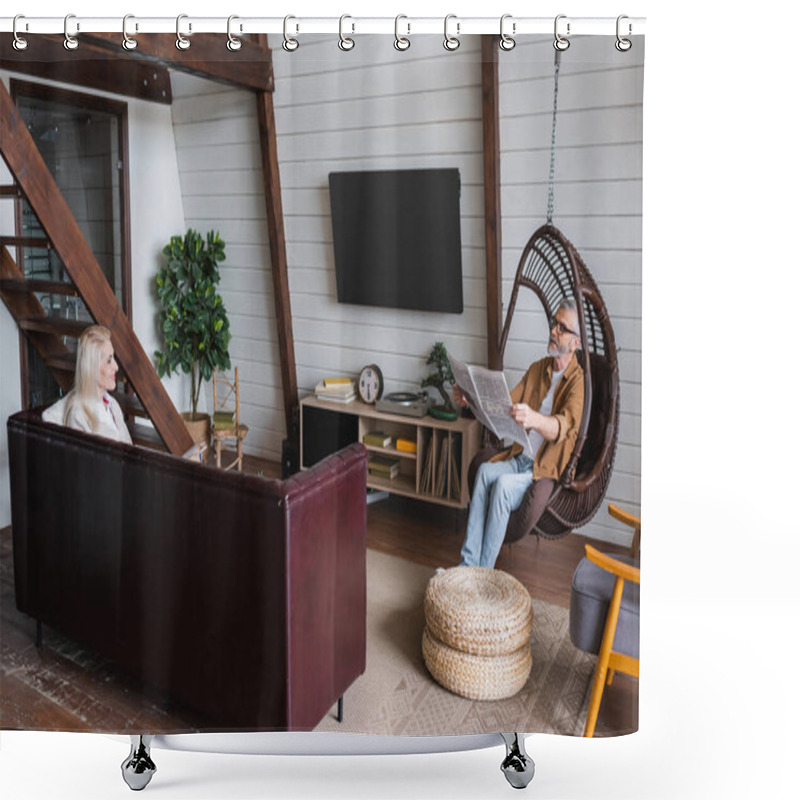 Personality  Smiling Senior Woman With Book Looking At Husband With Newspaper In Hanging Chair At Home  Shower Curtains