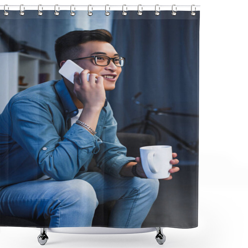 Personality  Smiling Young Asian Man In Eyeglasses Holding Mug And Talking By Smartphone Shower Curtains