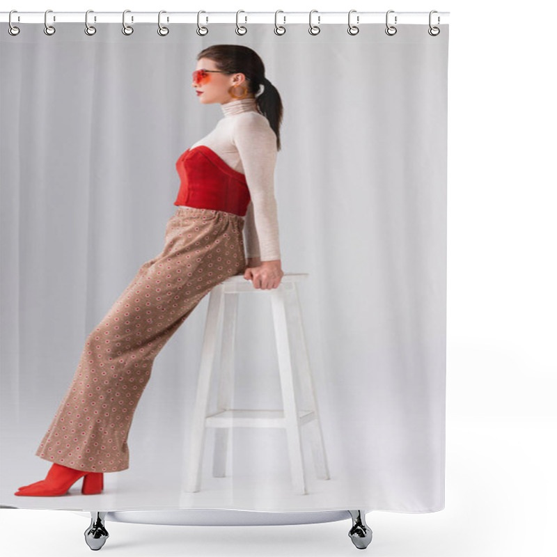 Personality  Side View Of Fashionable Girl In Beige Trousers And Red Corset On Turtleneck Leaning On Stool On Grey Shower Curtains