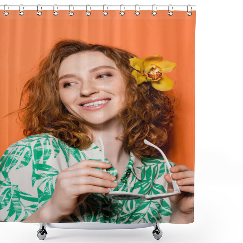 Personality  Positive Young Redhead Woman With Orchid Flower In Hair Wearing Blouse With Floral Pattern And Holding Sunglasses On Orange Background, Summer Casual And Trendy Concept, Youth Culture Shower Curtains