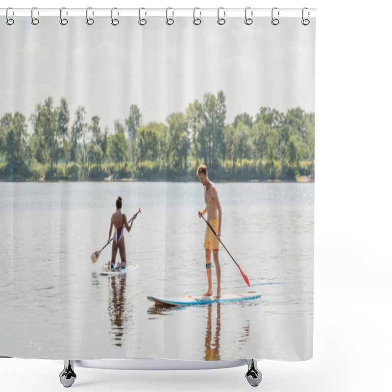 Personality  Young And Sportive Redhead Man Standing On Sup Board With Paddle Near African American Woman In Colorful Swimsuit Sailing On Picturesque Lake With Green Shore Shower Curtains