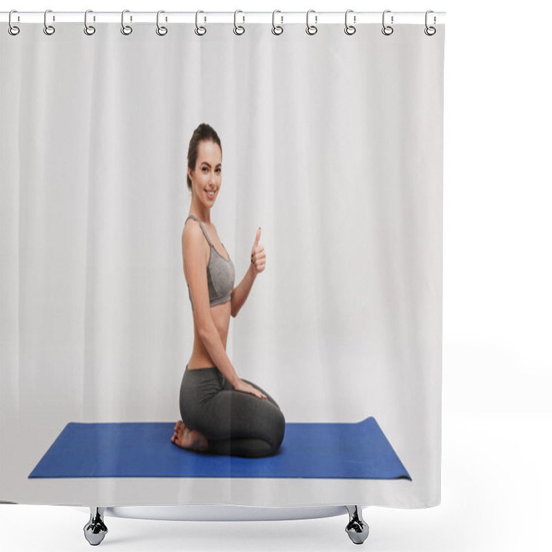 Personality  Side View Of Young Woman Sitting On Yoga Mat And Showing Thumb Up Isolated On White Shower Curtains