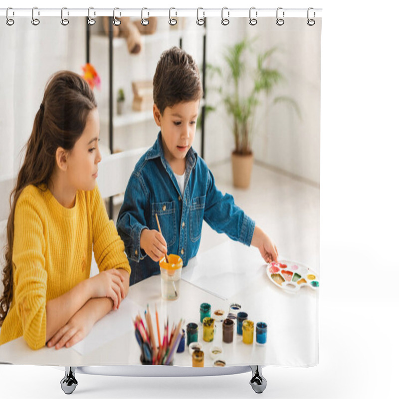 Personality  Cute Boy Dipping Paintbrush In Water And Touching Palette While Sitting At Table Near Sister Shower Curtains