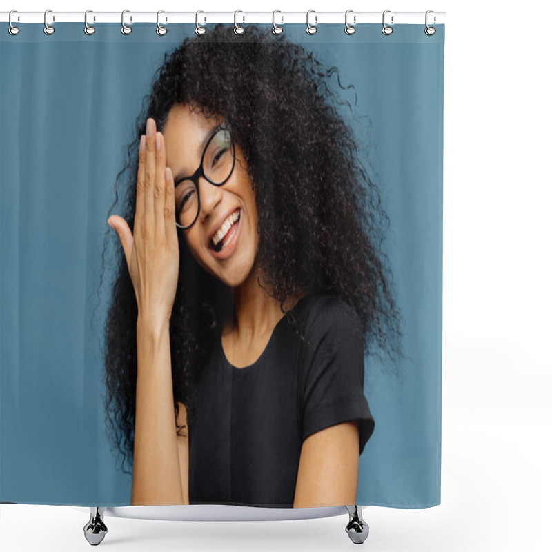 Personality  Happy Afro American Woman Touches Forehead, Tilts Head, Smiles Happily At Camera, Has Fun Indoor, Wears Optical Spectacles And Casual Black T Shirt, Isolated Over Blue Background. Emotions Concept Shower Curtains