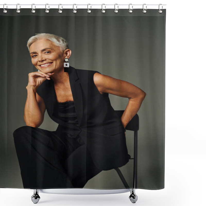 Personality  Positive, Cheerful Senior Woman In Black Attire Sitting On Chair With Hand Behind Back On Grey Shower Curtains