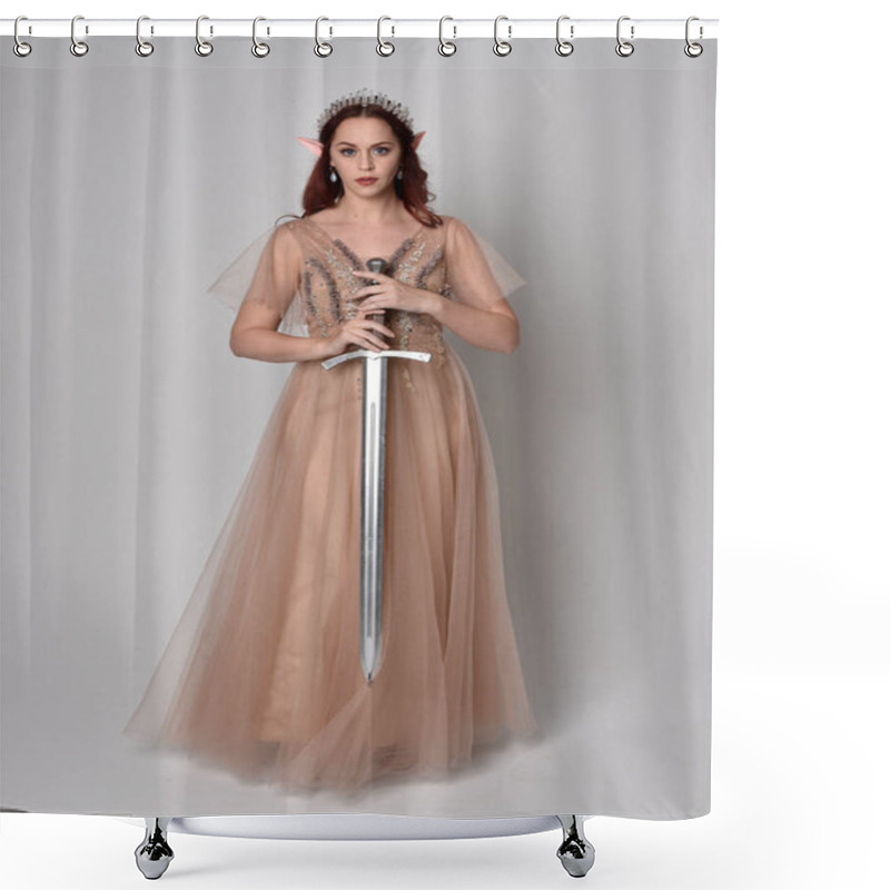 Personality  Full Length  Portrait Of Red Haired  Girl Wearing A Creamy Fantasy Gown And Crystal Crown, Like A Fairy Goddess Costume.  Standing Pose Holding A Sword Weapon  Isolated On Light Studio Background. Shower Curtains