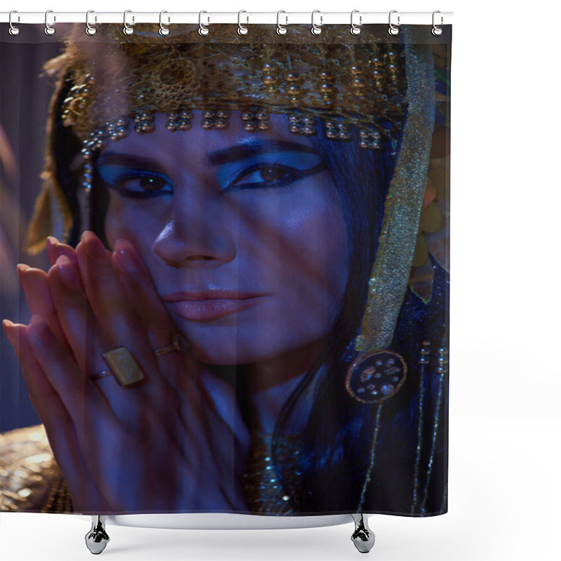 Personality  Portrait Of Woman With Makeup And Egyptian Headdress Looking At Camera In Blue Light On Brown Shower Curtains