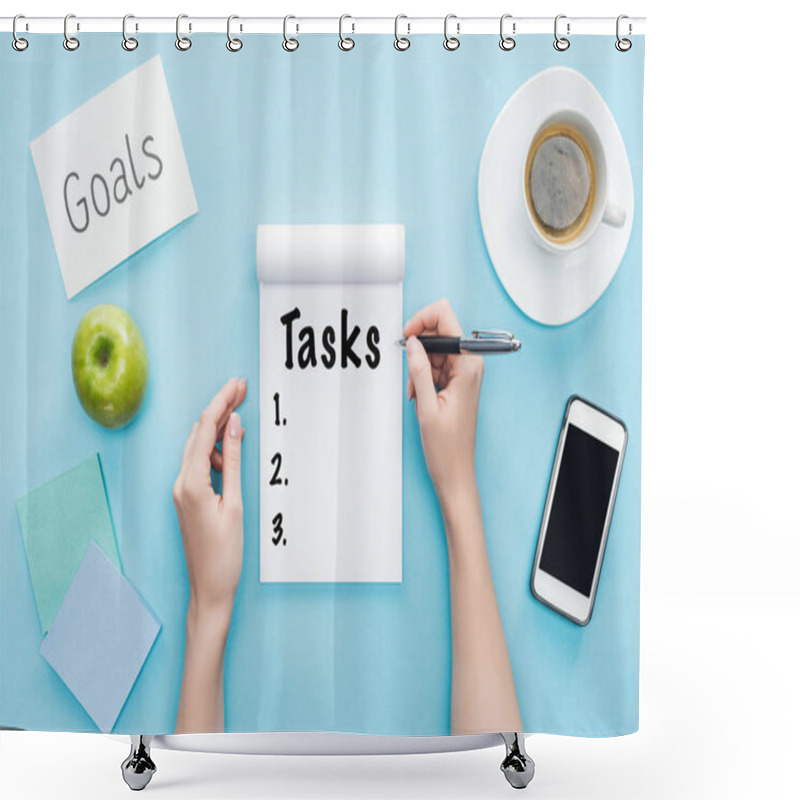 Personality  Cropped View Of Woman Writing Word 'tasks' In Notebook, Lettering 'goals' On Card, Coffee And Smartphone With Blank Screen On Blue Background  Shower Curtains