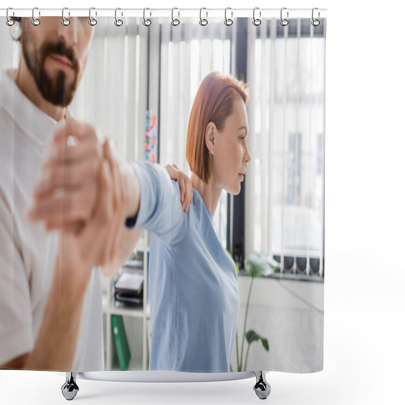 Personality  Redhead Woman With Injured Arm Near Blurred Physiotherapist Doing Diagnostics In Consulting Room Shower Curtains