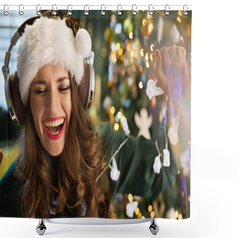 Personality  Christmas Time. Smiling Trendy Female With Santa Hat In Green Dress Listening To The Music With Headphones And Dancing Near Christmas Tree In The Modern House. Shower Curtains