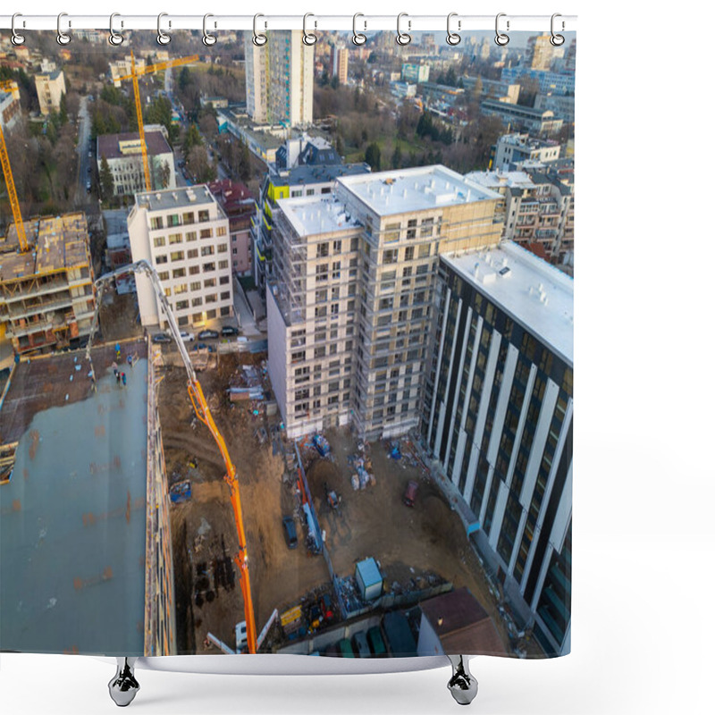 Personality  Aerial View Of A Construction Site With A High-rise Building Under Development. A Concrete Pump Pours Cement On The Rooftop, While Workers And Scaffolding Indicate Progress. Surrounded By Modern Shower Curtains