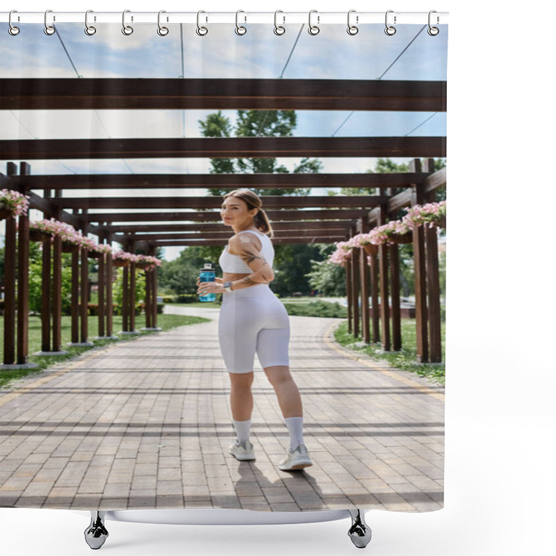 Personality  A Young Sportswoman, Dressed In White Activewear, Walks Along A Brick Path Under A Wooden Pergola, Holding A Water Bottle. Shower Curtains