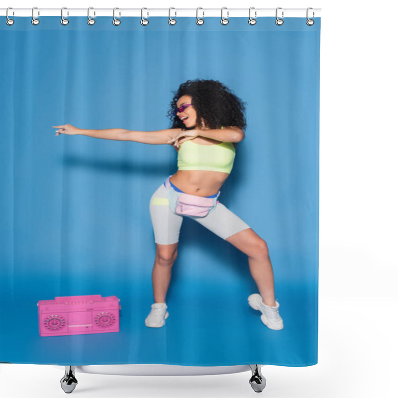 Personality  Full Length Of Happy African American Woman In Sunglasses And Waist Bag Pointing Near Pink Boombox On Blue Shower Curtains