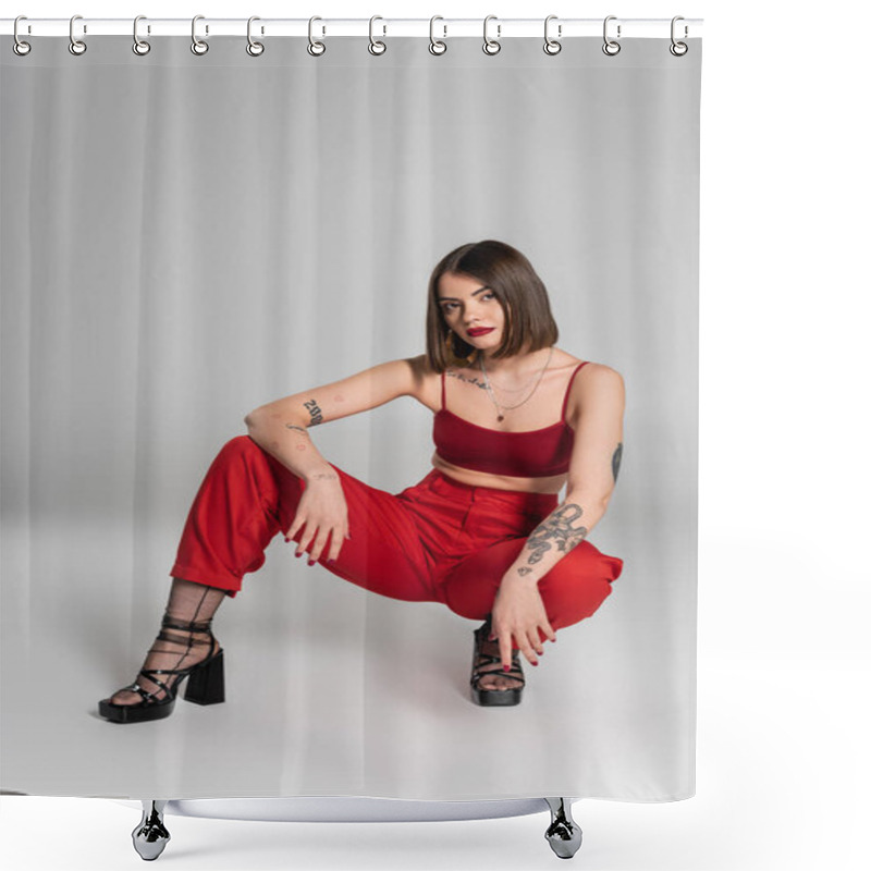 Personality  Full Length Of Young Model In Red Outfit, Tattooed Woman With Short Hair And Nose Piercing Posing In Red Crop Top And Pants While Sitting On Grey Background, Modern Style, Generation Z, Fashion Trend  Shower Curtains