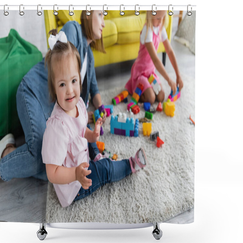 Personality  Toddler Kid With Down Syndrome Looking At Camera While Playing With Blurred Girl And Kindergarten Teacher On Carpet  Shower Curtains