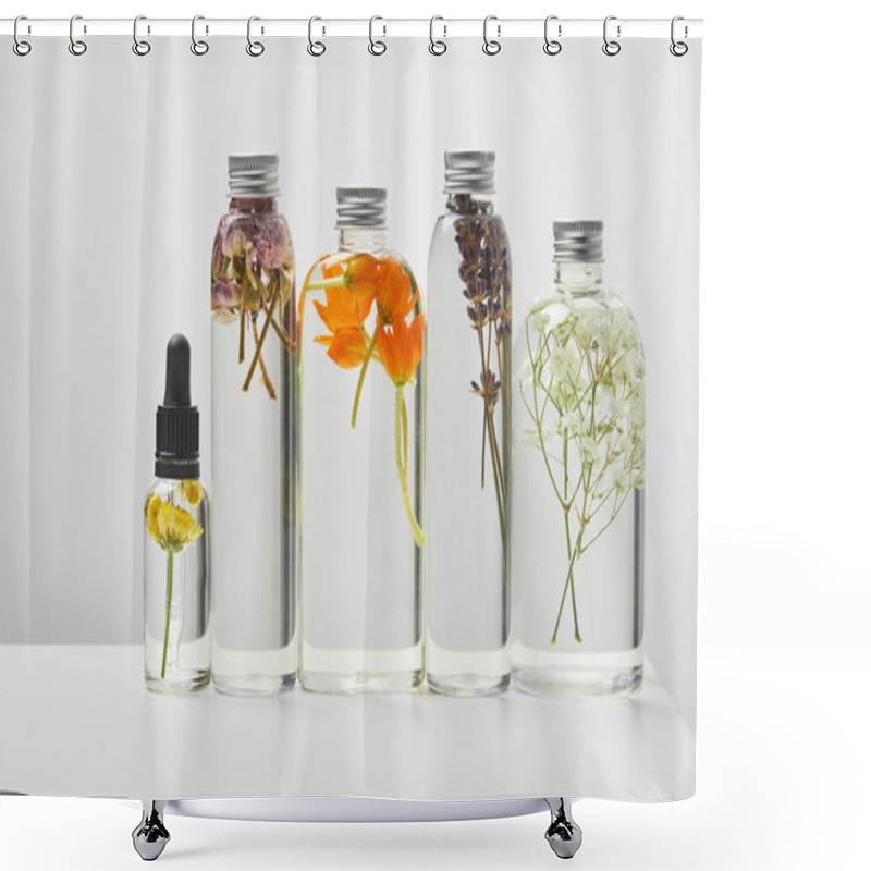 Personality  Organic Beauty Products In Transparent Bottles With Herbs And Wildflowers Arranged In Row On White Table Isolated On Grey  Shower Curtains