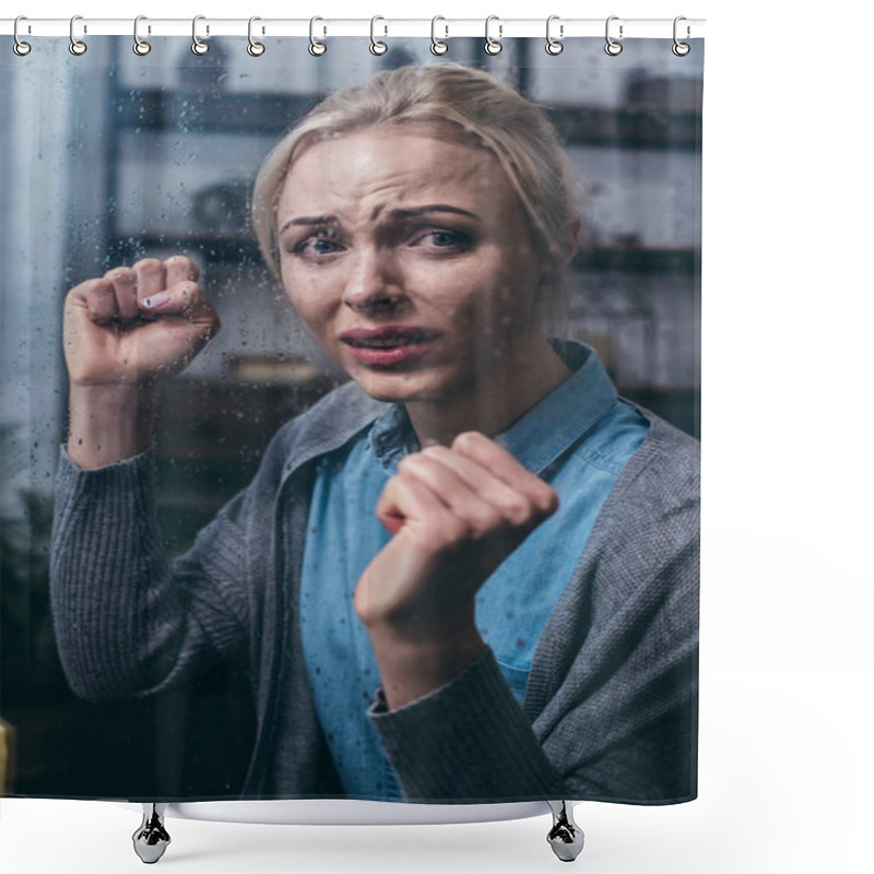 Personality   Stressed Adult Woman With Clenched Fists Looking At Camera At Home Through Window With Raindrops Shower Curtains