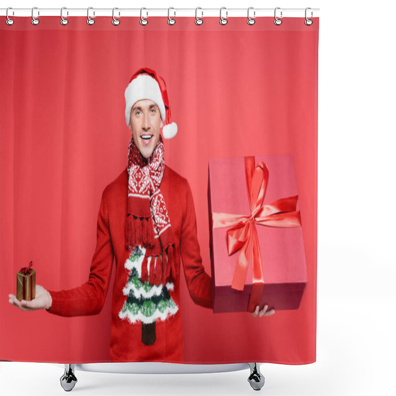 Personality  Positive Man In Sweater And Santa Hat Holding Gift Boxes On Red Background Shower Curtains