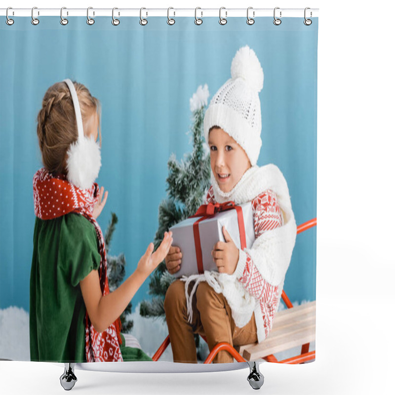 Personality  Boy In Knitted Hat Holding Present While Sitting On Sleight Near Girl In Winter Earmuffs Gesturing On Blue Shower Curtains