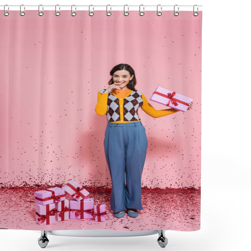 Personality  Pleased Woman In Blue Pants Holding Present And Looking At Camera Near Confetti And Gift Boxes On Pink Background Shower Curtains