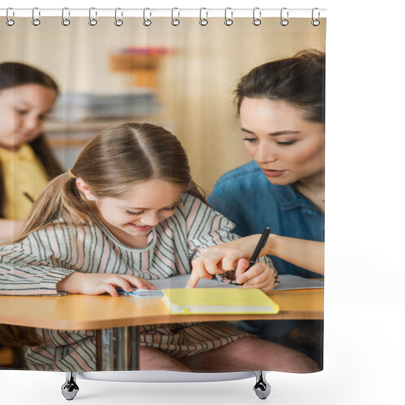 Personality  Young Teacher Pointing Near Smiling Kid Writing In Notebook And Asian Girl On Blurred Background Shower Curtains