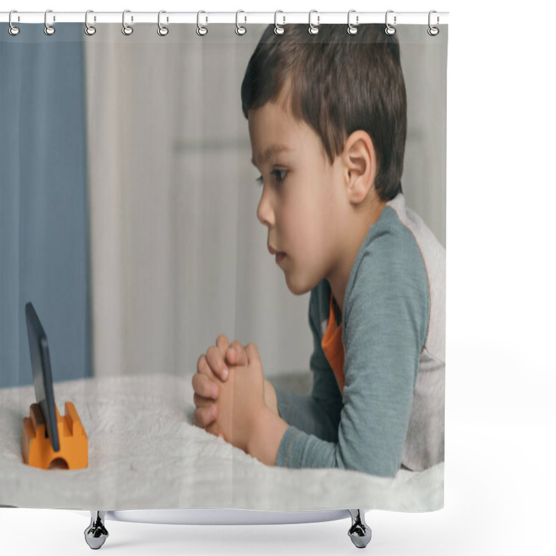 Personality  Side View Of Attentive, Cute Boy Lying On Bed And Watching Educational Cartoon On Smartphone Shower Curtains