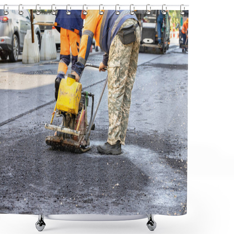 Personality  A Road Service Worker Compacts Fresh Asphalt On A Section Of Road With A Worn-out Gasoline Vibrating Plate Around A Sewer Manhole. Copy Space. Shower Curtains