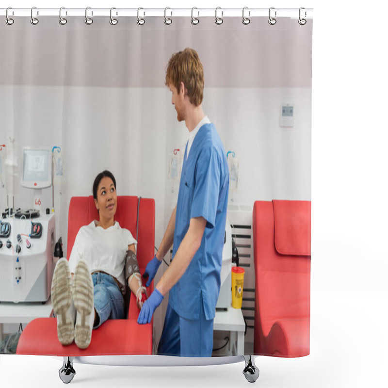 Personality  Multiracial Woman With Blood Pressure Cuff Sitting On Medical Chair Near Transfusion Machines And Looking At Redhead Doctor In Blue Uniform And Latex Gloves In Clinic Shower Curtains