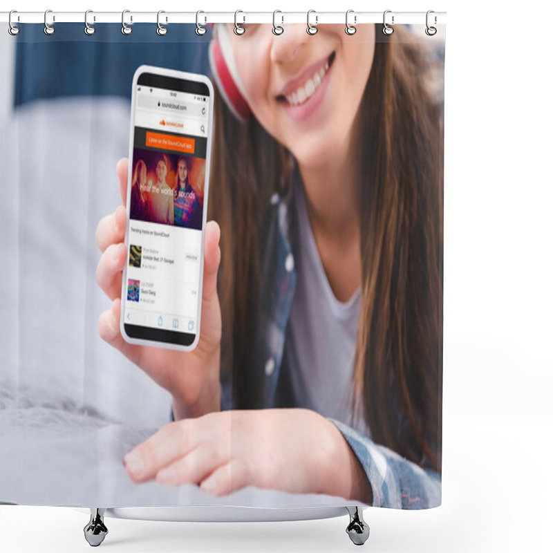 Personality  Cropped Shot Of Smiling Young Woman In Headphones Holding Smartphone With Soundcloud Application While Lying On Bed  Shower Curtains