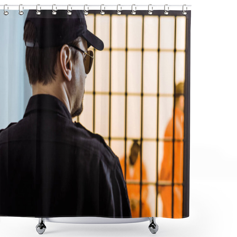 Personality  Rear View Of Prison Officer Standing Near Prison Cell With Criminals Shower Curtains