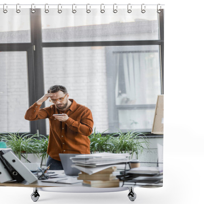 Personality  Worried Businessman In Eyeglasses Looking At Mobile Phone And Holding Hand Near Head Next To Work Desk With Laptop, Notebooks, Folders, Books, Paper Cup And Decorative Plants In Modern Office Shower Curtains