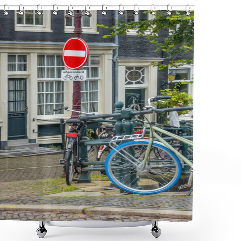 Personality  Netherlands. Amsterdam Canal Promenade With Traditional Houses And Parked Bicycles. Under The Prohibition Sign There Is A Sign In Dutch 