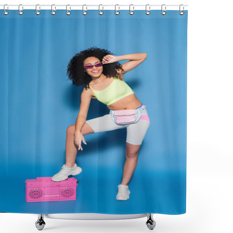 Personality  Full Length Of Cheerful African American Woman In Sunglasses And Waist Bag Posing Near Pink Boombox On Blue Shower Curtains