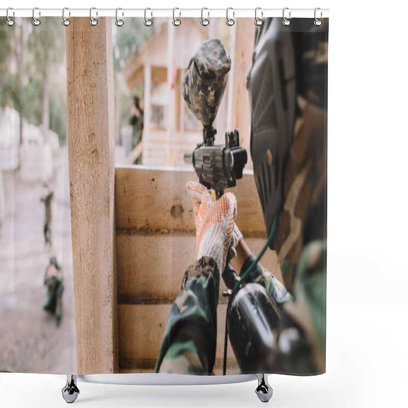 Personality  Selective Focus Of Paintball Player In Camouflage Uniform Aiming By Paintball Gun From Wooden Tower Outdoors  Shower Curtains