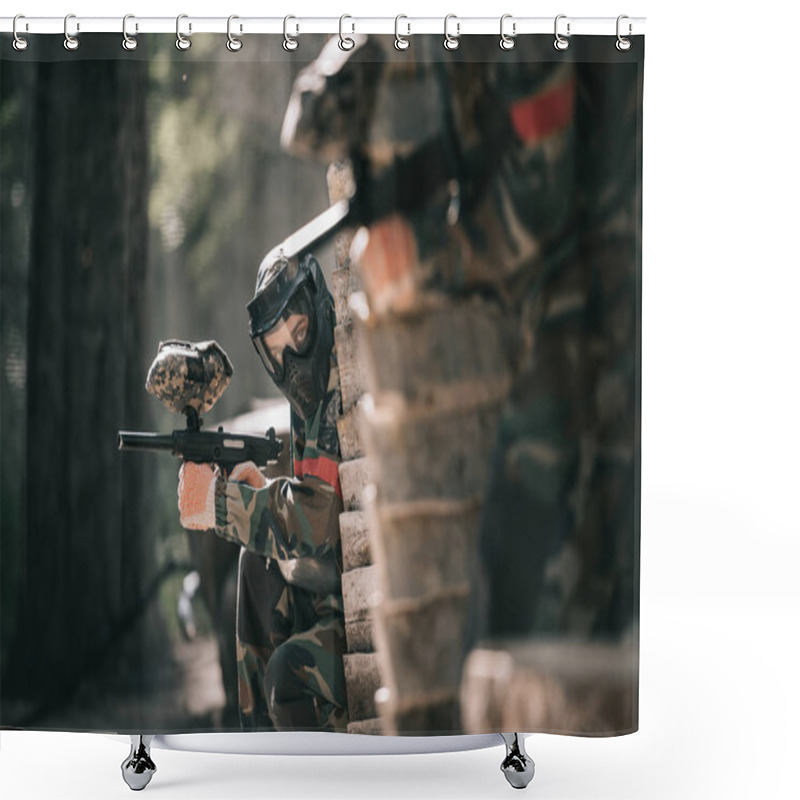 Personality  Selective Focus Of Paintball Player In Protective Mask Holding Marker Gun And His Teammate Hiding Behind Wooden Wall Outdoors Shower Curtains