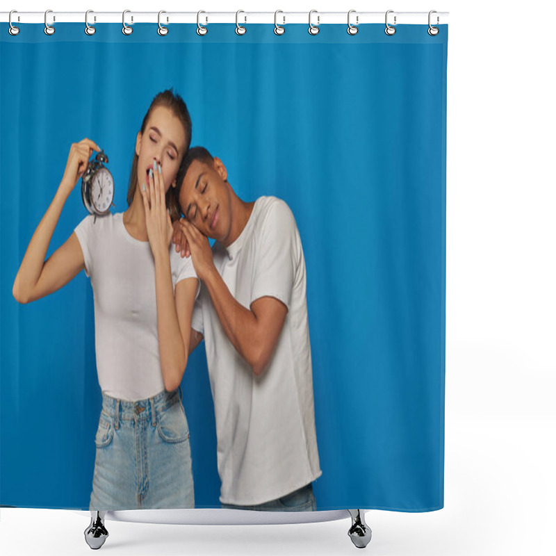 Personality  woman holding alarm clock and sleeping with african american man on blue backdrop, tired couple shower curtains