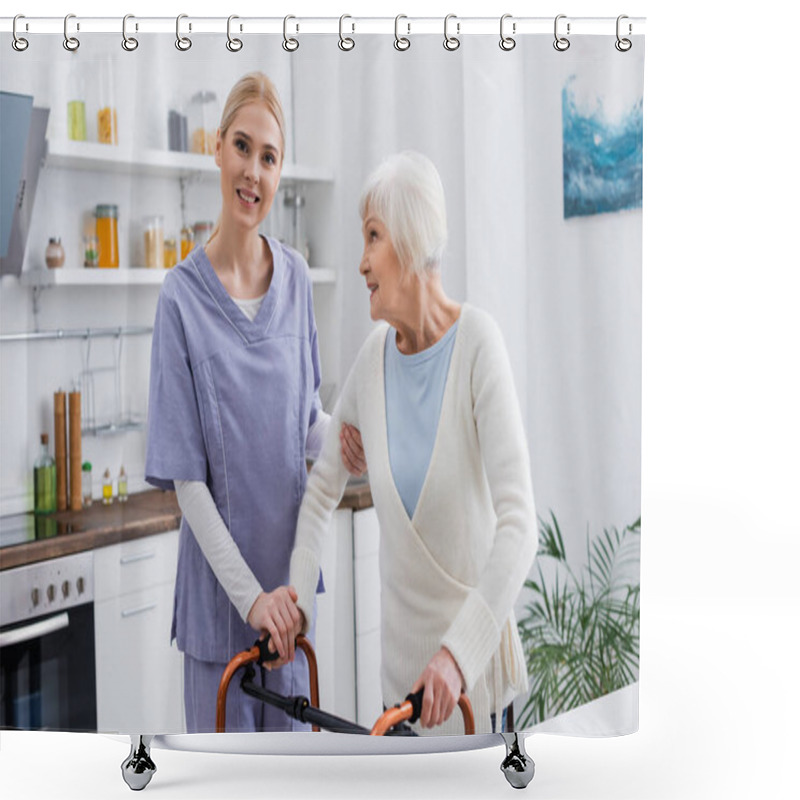 Personality  Young Nurse Smiling At Camera While Supporting Aged Woman Near Medical Walkers Shower Curtains