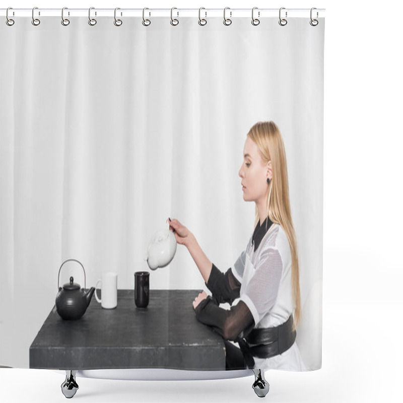 Personality  Side View Of Beautiful Caucasian Blonde Woman In Fashionable Black Clothes Pouring Tea In Cup Isolated On White Shower Curtains