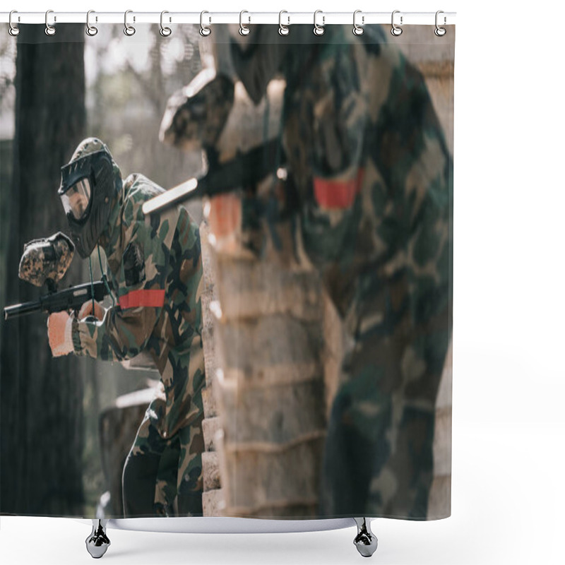 Personality  Selective Focus Of Paintball Player In Protective Mask Holding Marker Gun And His Teammate Hiding Behind Wooden Wall Outdoors Shower Curtains