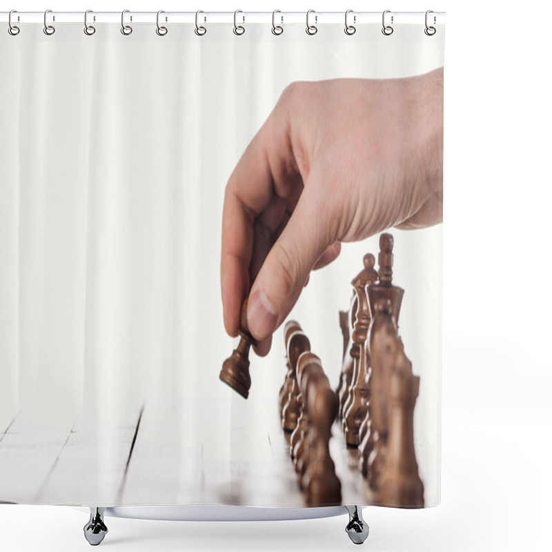 Personality  partial view of man doing move with brown pawn on wooden chessboard isolated on white shower curtains