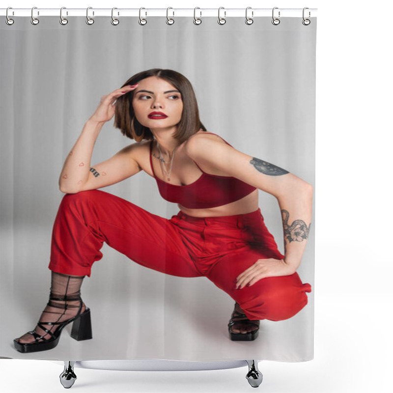 Personality  Fashion Trend, Young Model In Red Outfit, Tattooed Woman With Short Hair And Nose Piercing Posing In Red Crop Top And Pants While Sitting On Grey Background, Modern Style, Generation Z, Full Length  Shower Curtains