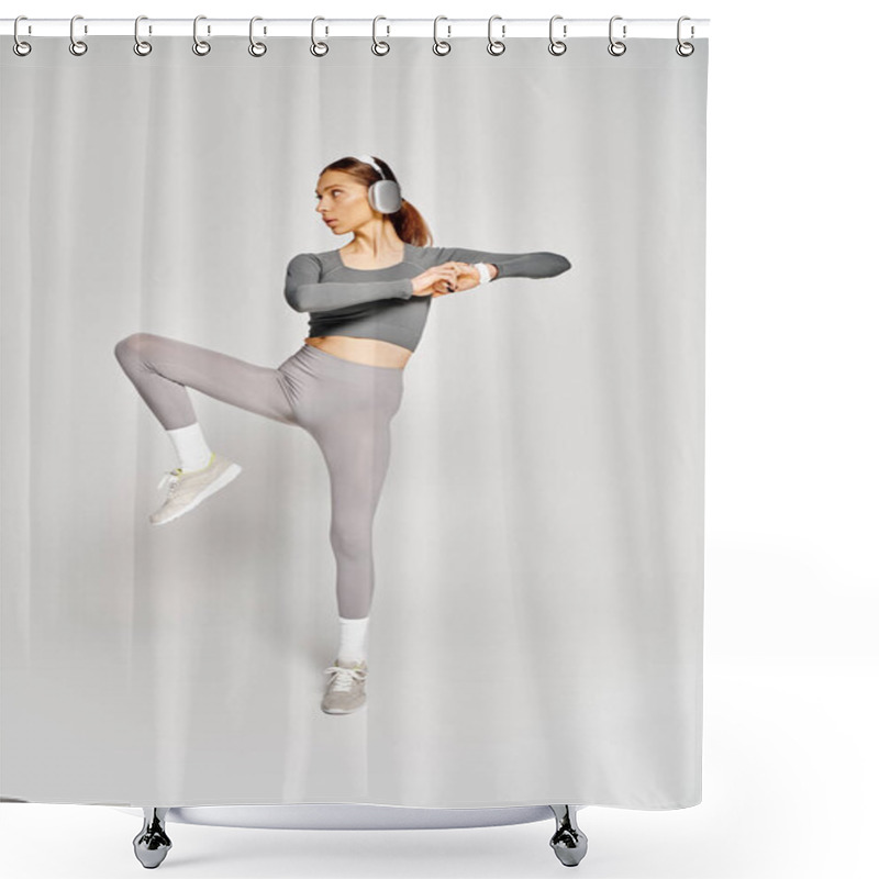 Personality  A Sporty Young Woman In A Gray Top And Grey Pants Elegantly Performs A Kick On A Matching Gray Background. Shower Curtains