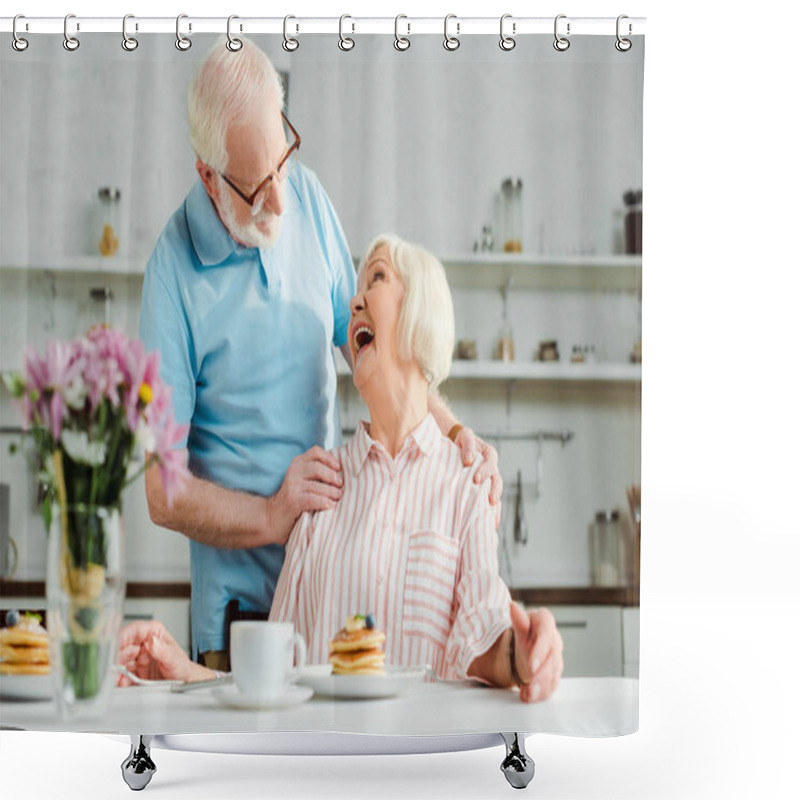 Personality  Selective Focus Of Senior Woman Laughing While Looking At Husband By Coffee And Pancakes On Table In Kitchen Shower Curtains