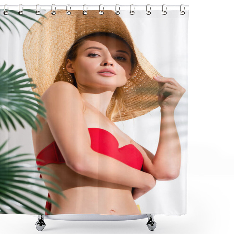 Personality  Young Woman Touching Straw Hat While Looking At Camera Near Blurred Palm Leaves On White Shower Curtains