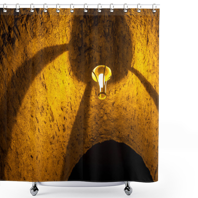 Personality  Close-up Of A Lit Arch With A Lamp Casting Shadows On The Stone Surface. The Golden Light Highlights The Texture, Creating A Mysterious And Atmospheric Scene Shower Curtains